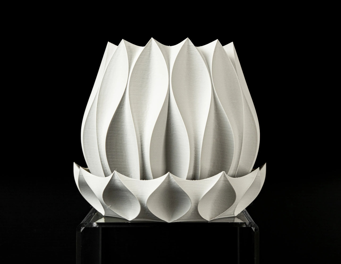 Pot décoratif blanc en matériau durable, design contemporain avec motifs ondulés sculptés en relief, base ajourée.