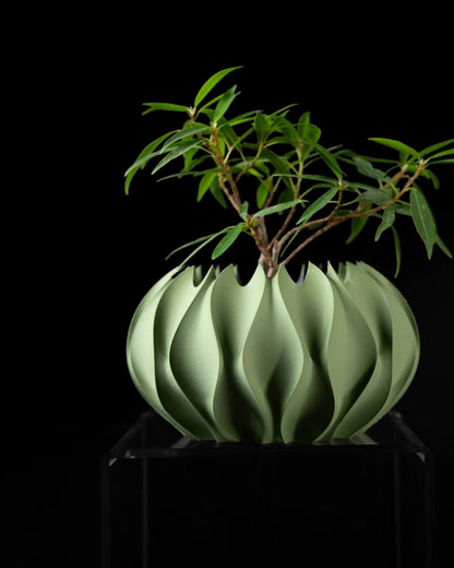 Pot décoratif vert clair en matériau durable avec design contemporain ondulé, forme sculpturale moderne.
