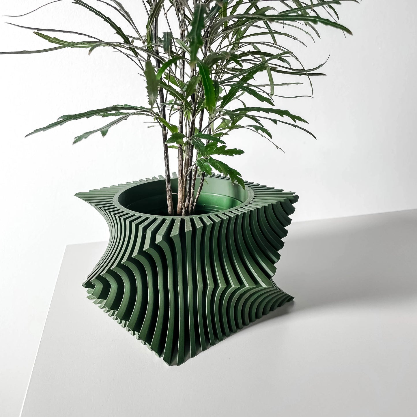 Pot décoratif vert forêt en matériau durable avec design contemporain ondulé et structure sculpturale.