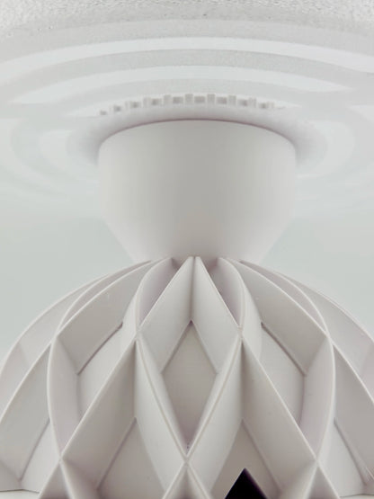 Lampe de table design contemporain en plastique durable blanc translucide lisse avec structure sculpturale géométrique.