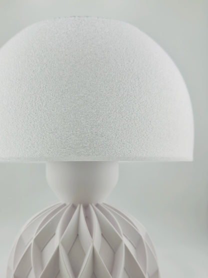 Lampe de table design contemporain blanche en plastique durable avec abat-jour texturé et base sculpturale géométrique.