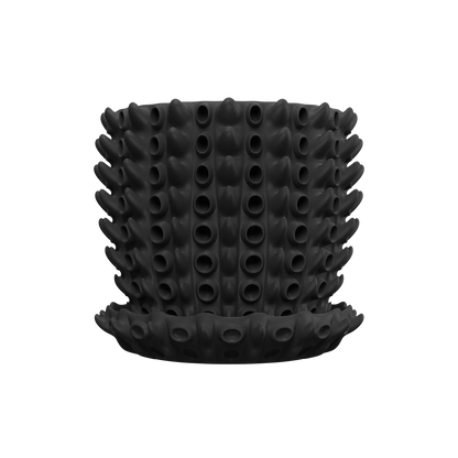 Pot décoratif noir mat en silicone avec motif de protubérances tubulaires cylindriques uniformes, accompagné d'une soucoupe.