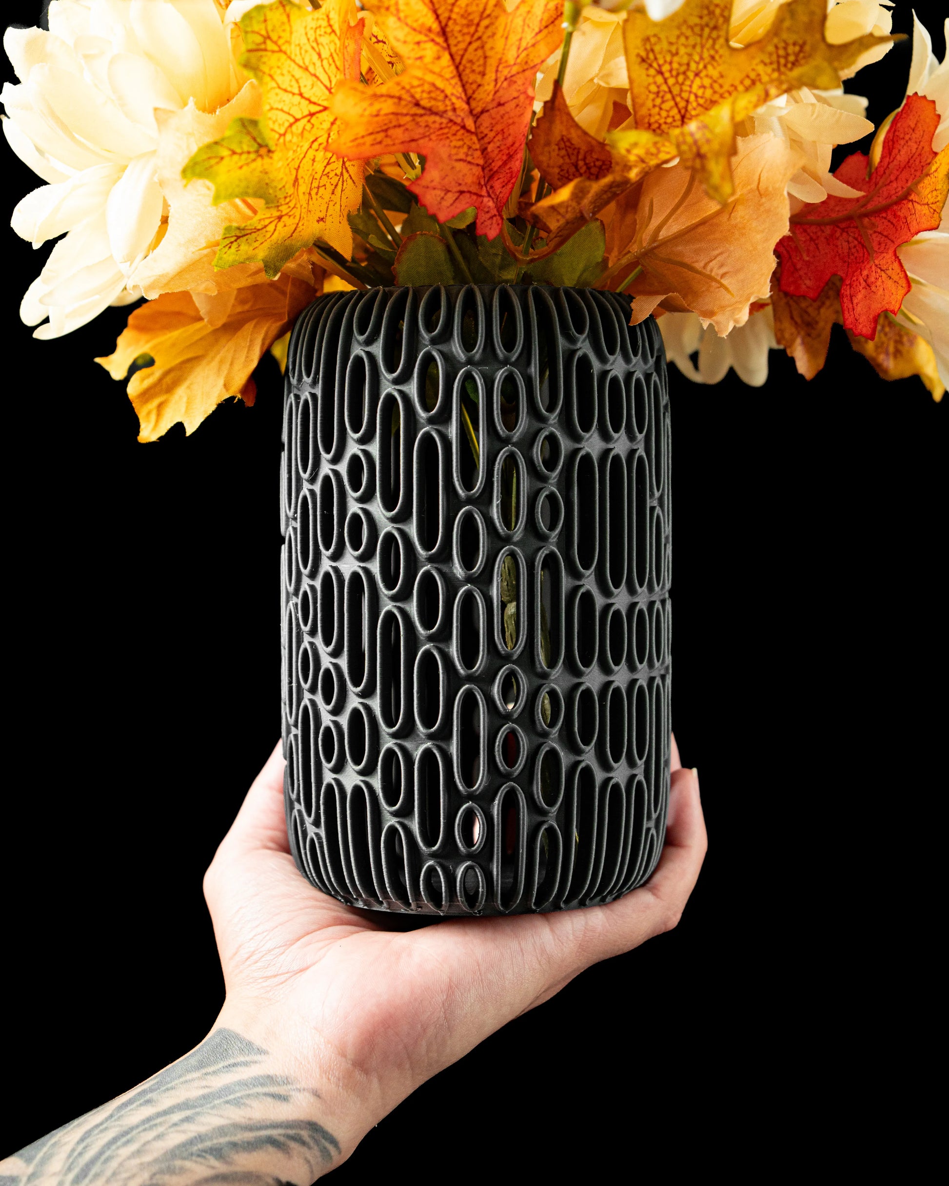Vase anthracite mat avec motif ovale en relief, design contemporain et durable, tenu à la main avec fleurs séchées jaunes et .
