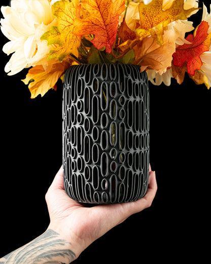 Vase anthracite mat avec motif ovale en relief, design contemporain et durable, tenu à la main avec fleurs séchées jaunes et .