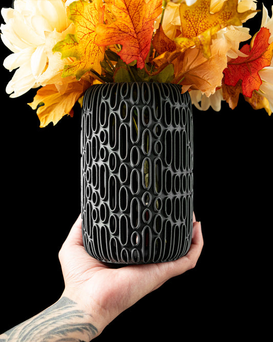 Vase anthracite mat avec motif ovale en relief, design contemporain et durable, tenu à la main avec fleurs séchées jaunes et .