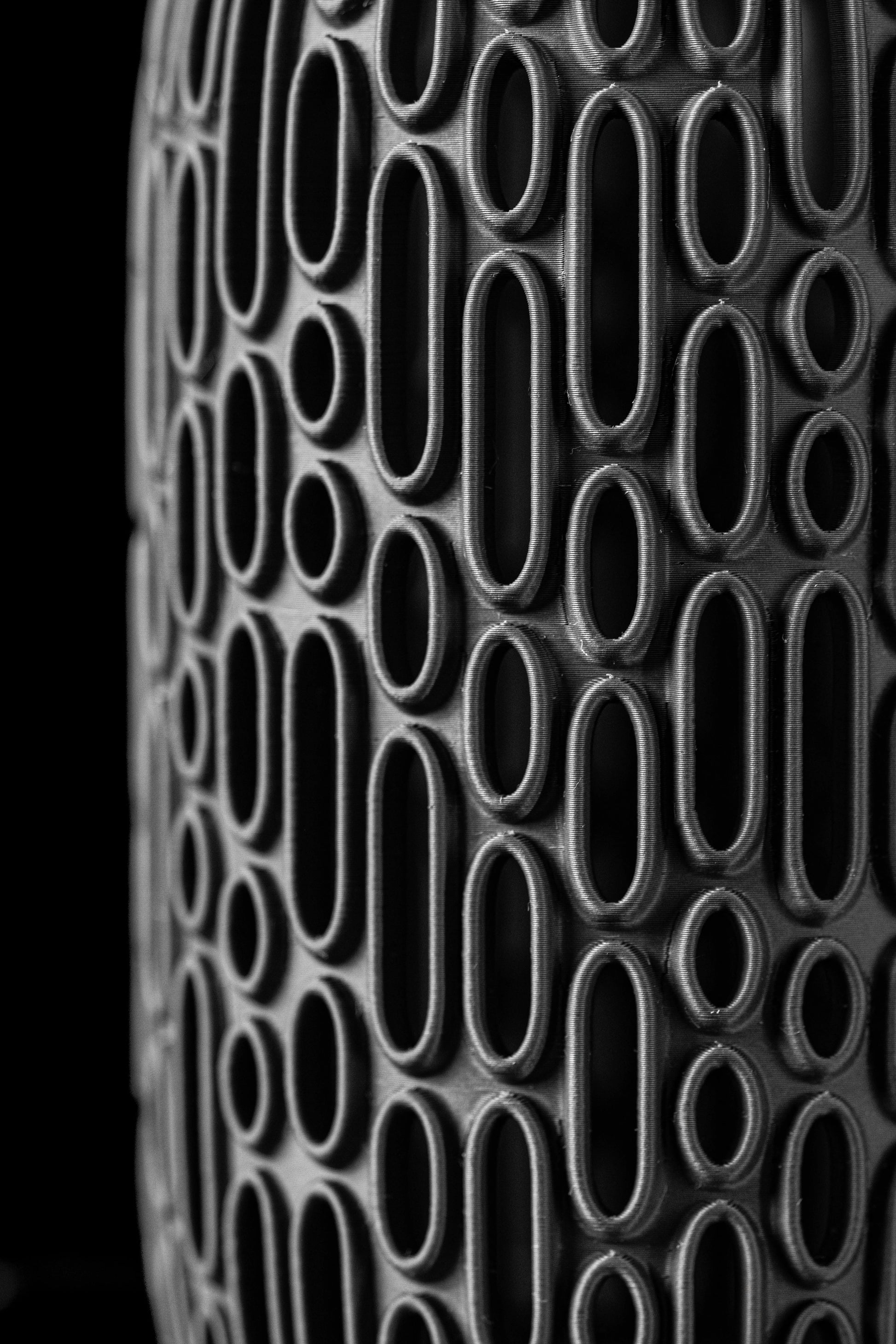 Vase moderne noir avec reliefs ovales en relief couvrant toute sa surface, finition mate et élégante.