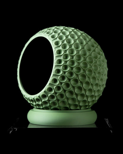 Pot décoratif vert menthe en forme de sphère avec texture de bulles circulaires, base ronde plate, intérieur creux noir.