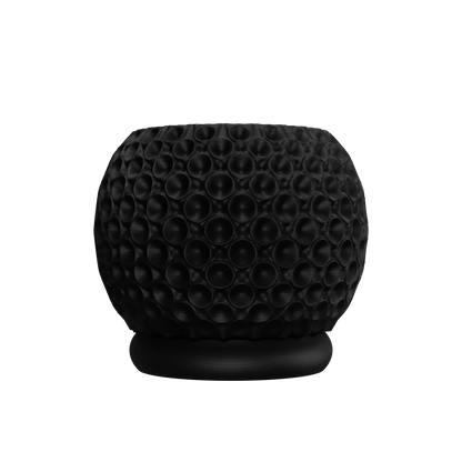 Pot décoratif noir mat avec surface texturée en relief de formes sphériques, base circulaire plate.