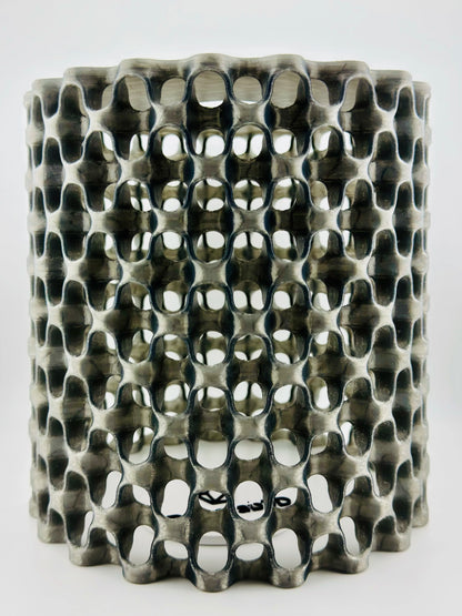 Suspension contemporaine noire en polycarbonate translucide ajouré, motif maillage durable et design moderne.