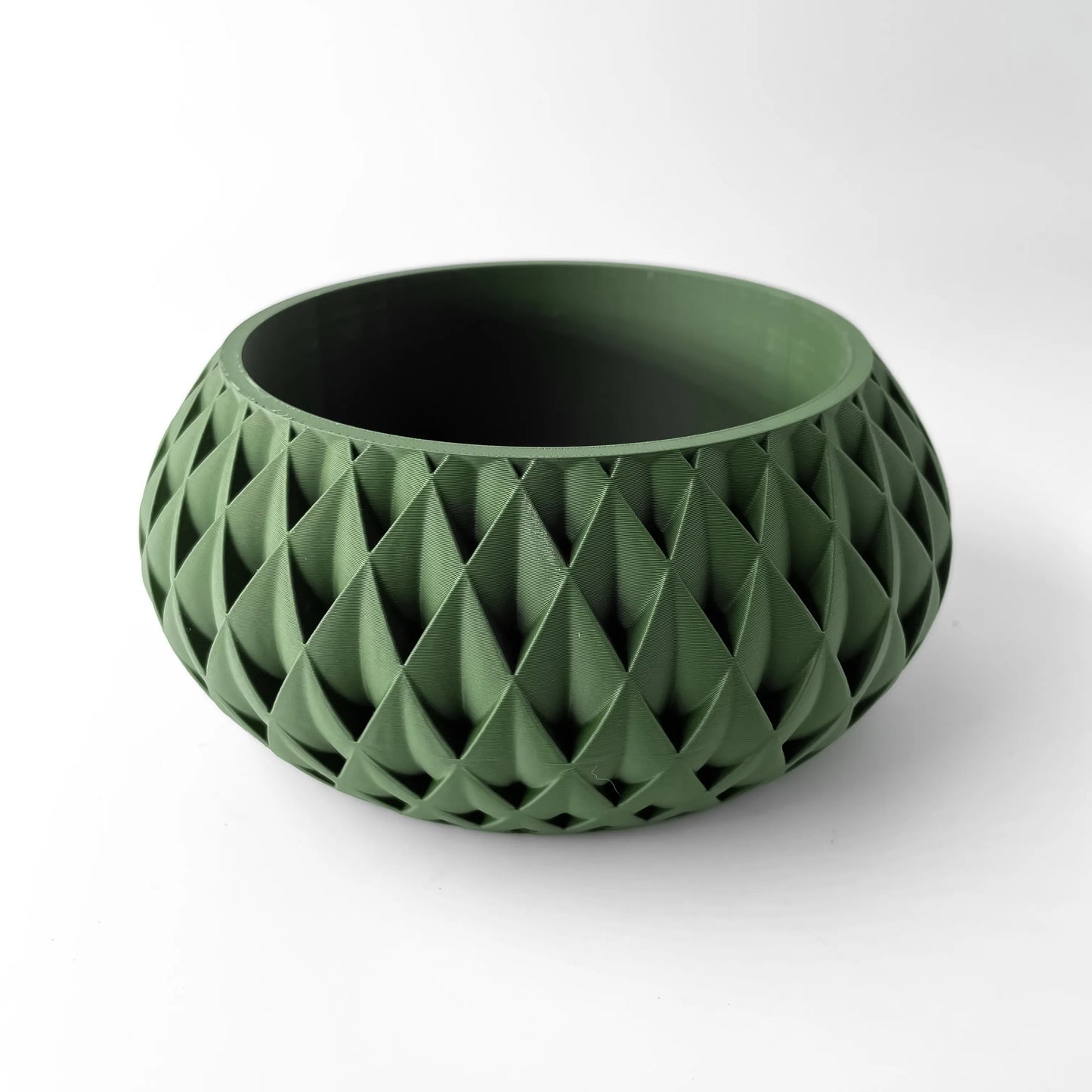 Pot décoratif vert olive en plastique moderne avec surface géométrique texturée en relief, forme ronde évasée.