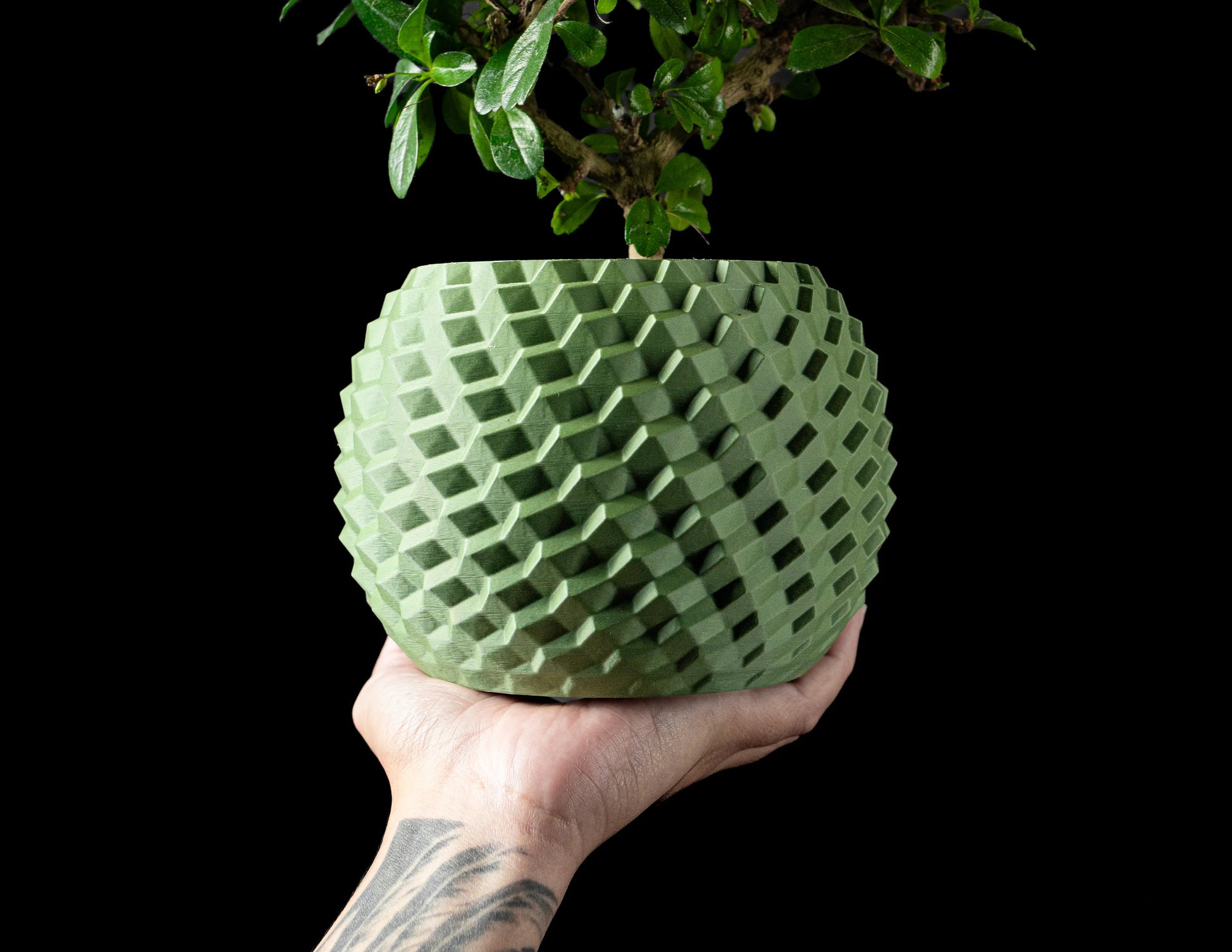 Pot décoratif vert forêt au design contemporain en matériau durable avec texture géométrique tridimensionnelle.