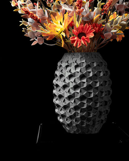Vase durable anthracite avec design contemporain en forme de galets texturés, fleurs séchées colorées à l’intérieur.
