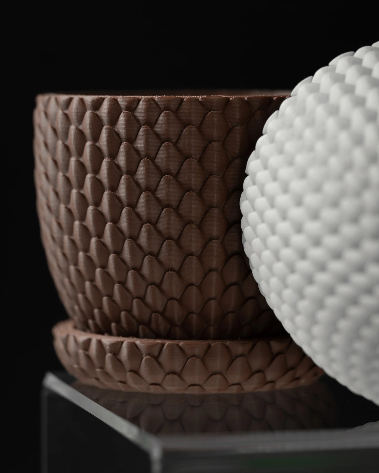 Pot décoratif marron à surface texturée imitant des écailles de dragon avec soucoupe assortie, design moderne et minimaliste.