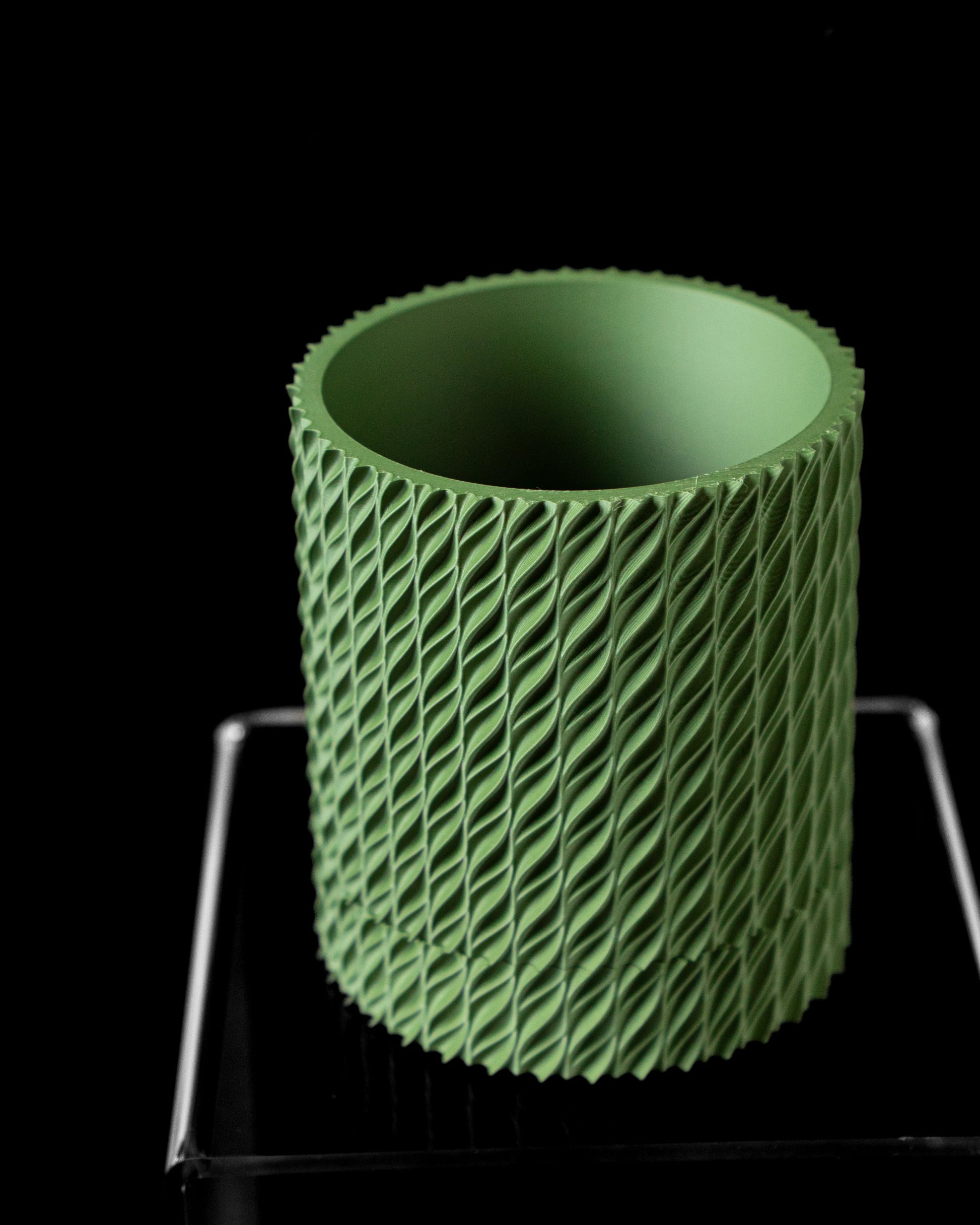 Pot décoratif vert forêt en matériau durable avec design contemporain et surface texturée en torsades.