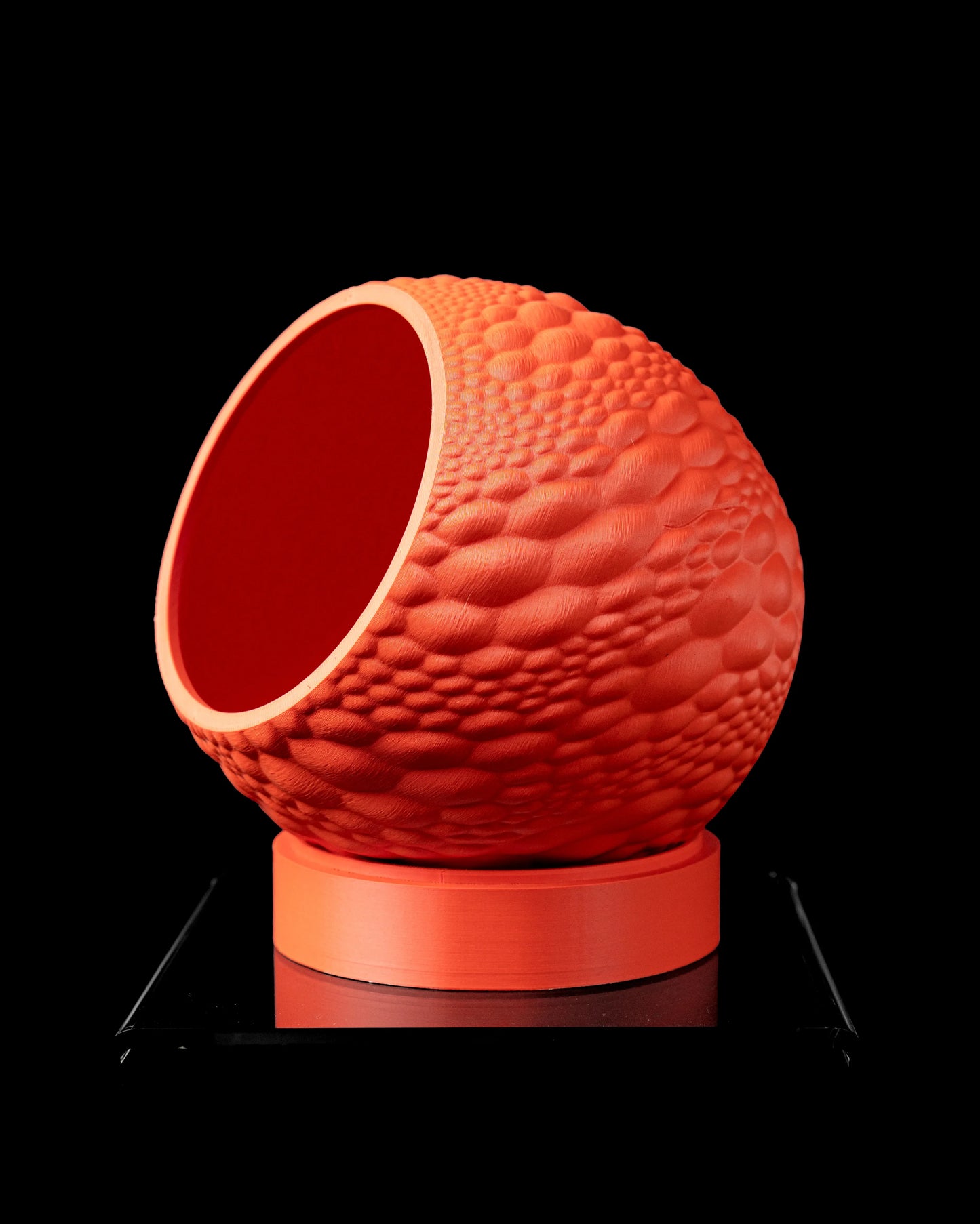 Pot décoratif rond orangé avec texture bosselée irrégulière et base plate circulaire, style moderne.