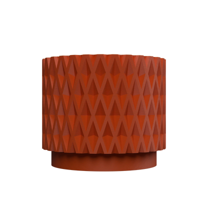 Pot décoratif cylindrique en métal rouge brique avec motif géométrique en relief en forme de losanges multidirectionnels.