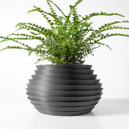 Pot décoratif anthracite en matériau durable, forme contemporaine avec rainures horizontales, plante verte luxuriante.