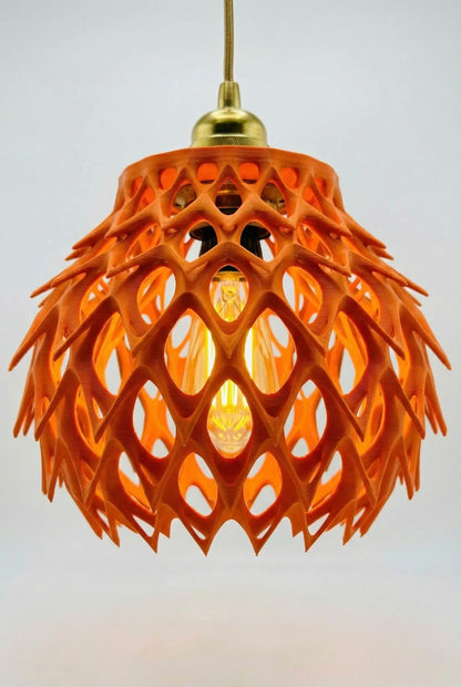 Suspension design contemporain orange en plastique ajouré, durable avec structure légère et formes géométriques ouvertes.