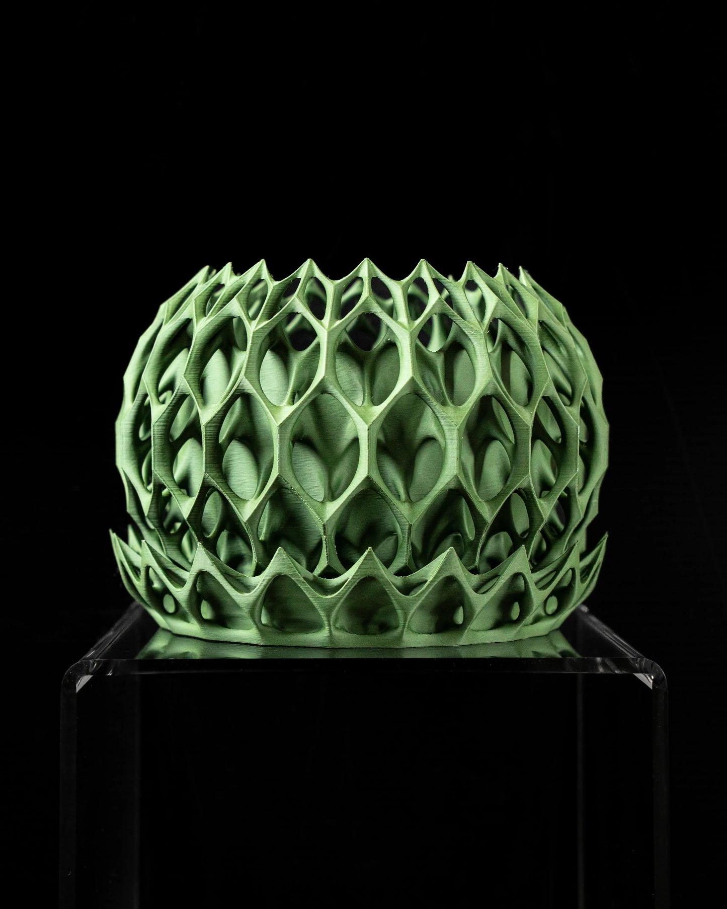 Pot décoratif vert forêt en matériau durable avec design contemporain à motifs géométriques ajourés.