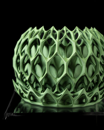 Pot décoratif vert anis en résine avec texture en treillis organique complexe, forme arrondie et bord festonné irrégulier.