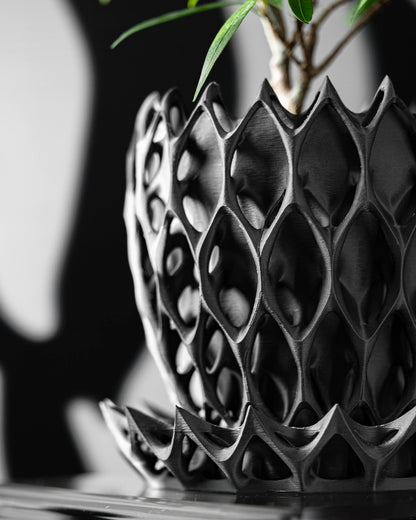 Pot décoratif anthracite durable au design contemporain en matériau moderne texturé avec motifs géométriques ajourés.