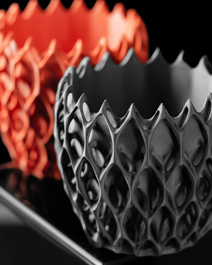 Pot décoratif Invader en plastique durable noir avec design contemporain à reliefs géométriques, fond noir avec un pot rouge .