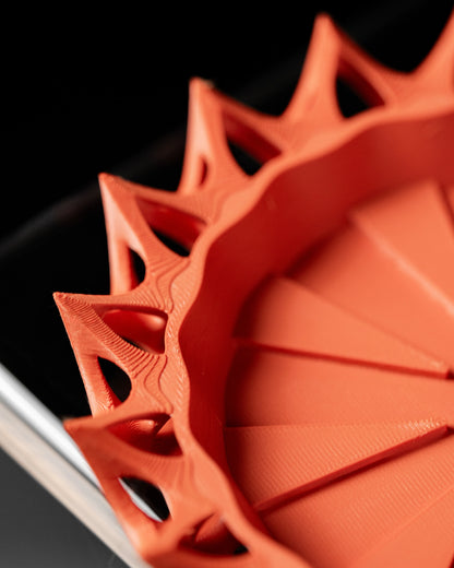 Pot décoratif Invader rouge en matériau durable au design contemporain avec reliefs triangulaires ajourés.