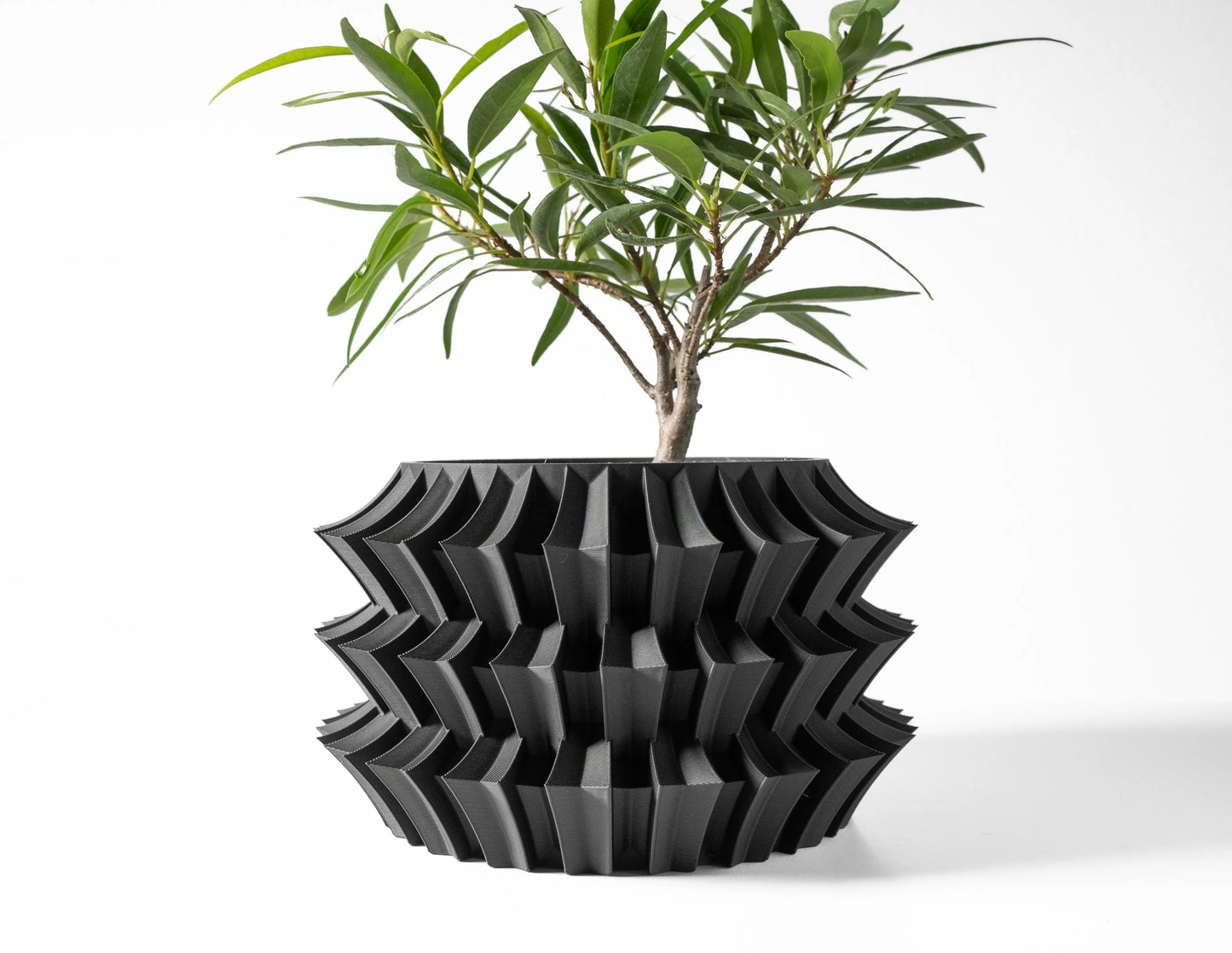 Pot décoratif anthracite au design contemporain, structure ondulée en matériau durable, style moderne et sculptural.