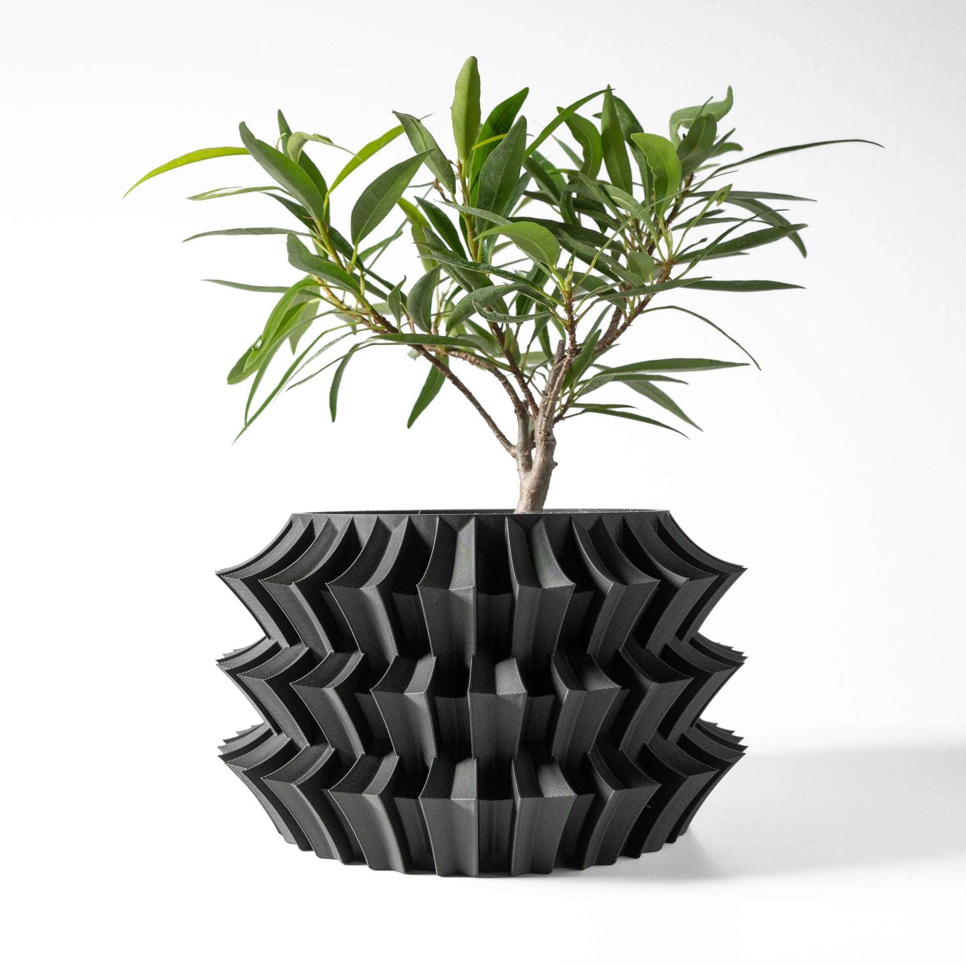 Pot décoratif anthracite en matériau durable avec design contemporain texturé et formes géométriques marquées.