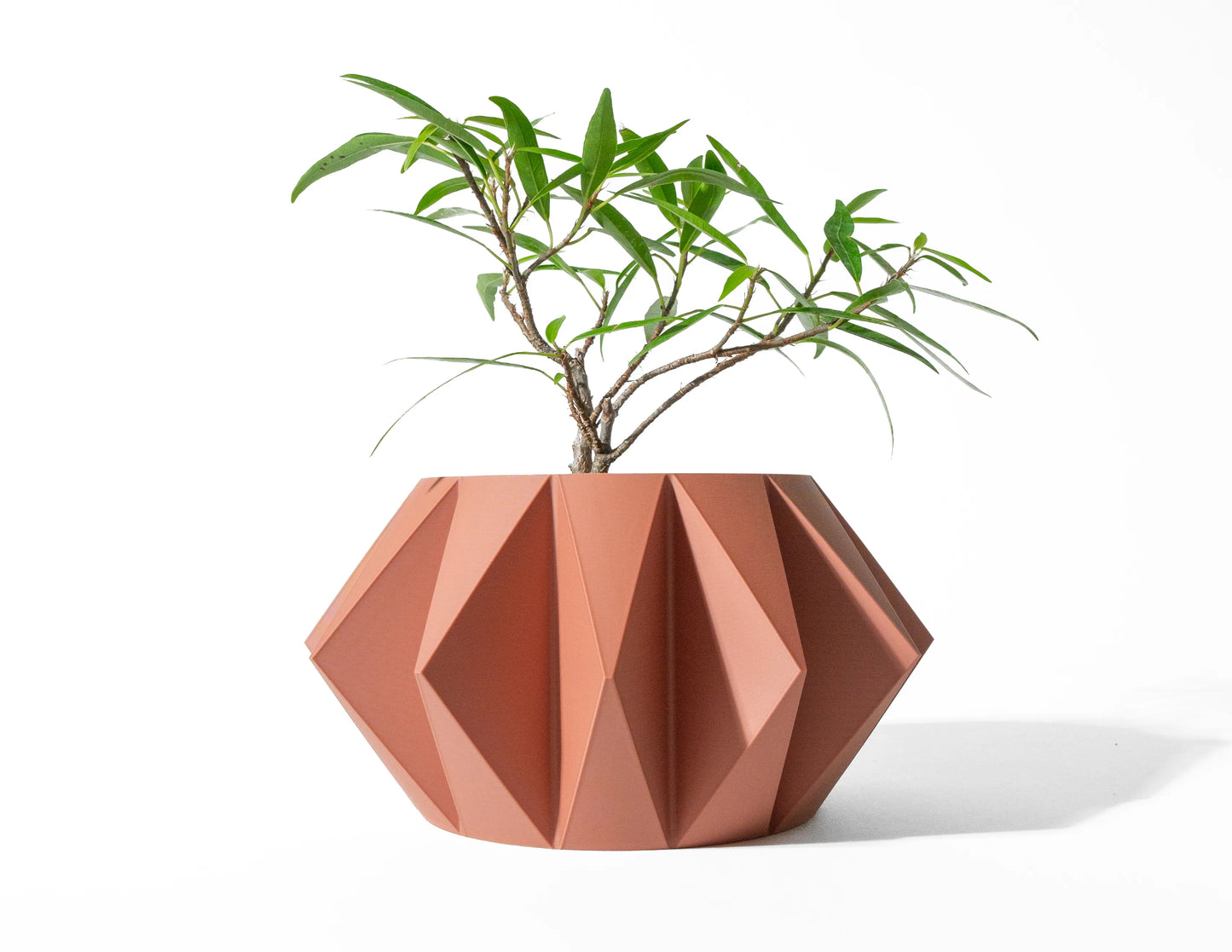 Pot décoratif Koni orange en matériau durable avec design contemporain géométrique façonné en facettes angulaires.