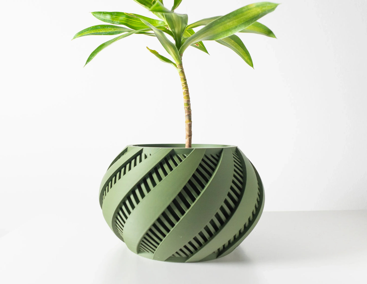 Pot décoratif Krato vert forêt à rayures diagonales noires, design contemporain durable en matériau robuste.