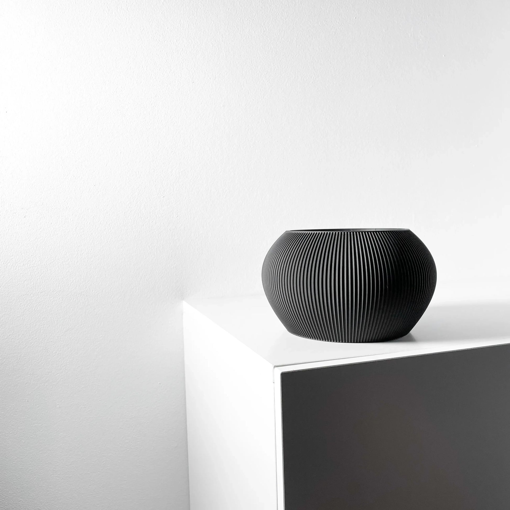 Pot décoratif anthracite en matériau durable avec design contemporain et surface texturée rayée.