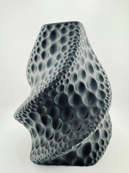 Vase sculptural noir mat avec texture torsadée en relief, design contemporain durable et étanche.