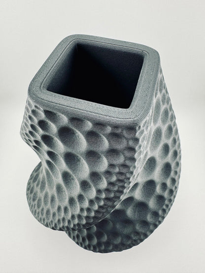 Vase noir mat sculptural avec surface texturée en relief, design contemporain et durable, pièce étanche unique.