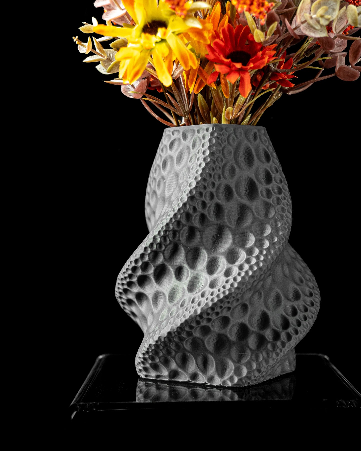 Vase gris torsadé avec texture alvéolée évoquant la surface lunaire, silhouette sculpturale et contemporaine.