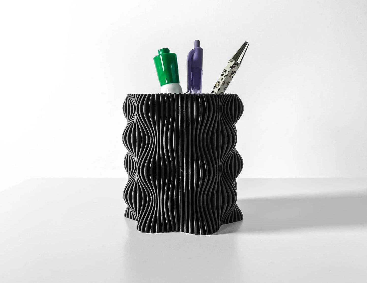 Pot décoratif anthracite en plastique durable avec design contemporain à surface ondulée, utilisé comme porte-stylos.