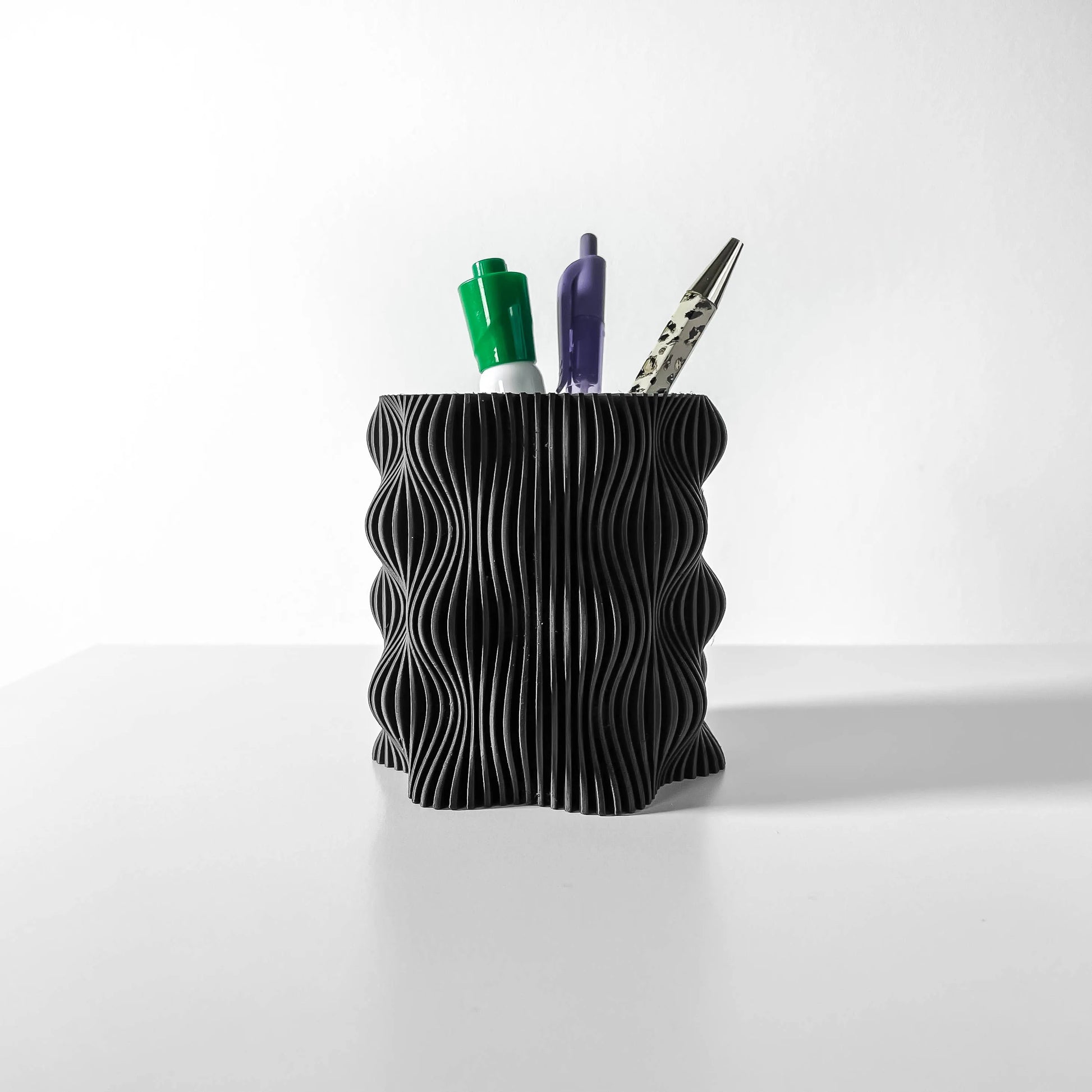 Pot décoratif anthracite en plastique durable avec surface ondulée et design contemporain, parfait pour bureau.