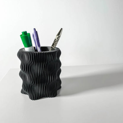 Pot décoratif anthracite en matériau durable avec design contemporain ondulé, utilisé comme porte-stylos.