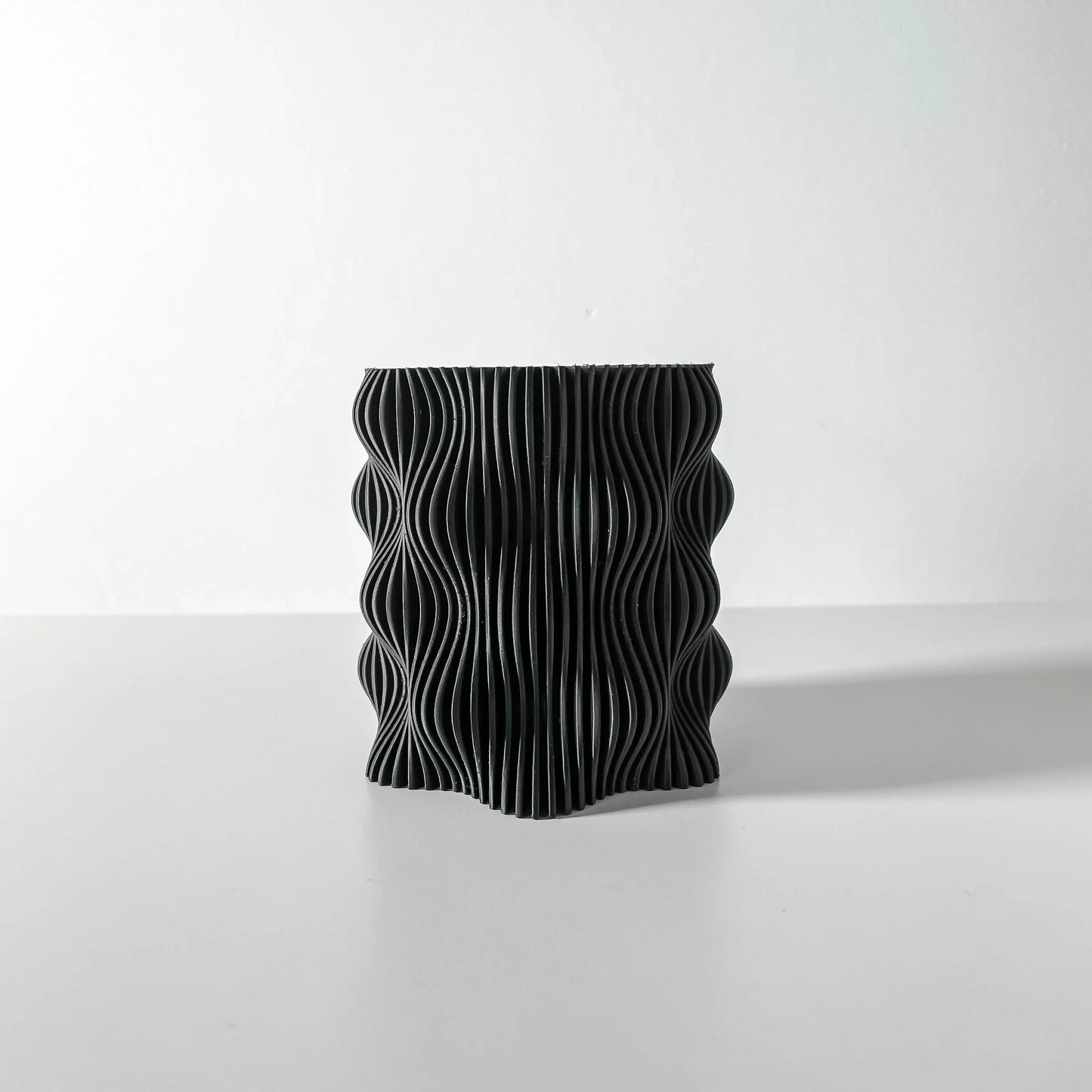 Pot décoratif anthracite en matériau durable avec design contemporain ondulé et texturé.
