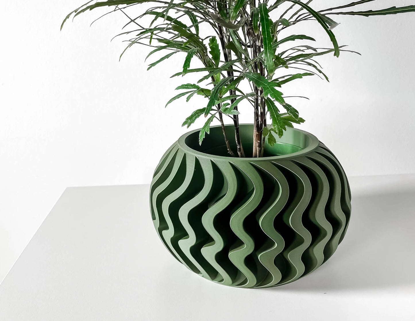 Pot décoratif Noli vert forêt avec motifs ondulés en gris, forme ronde, design contemporain durable en matière robuste.
