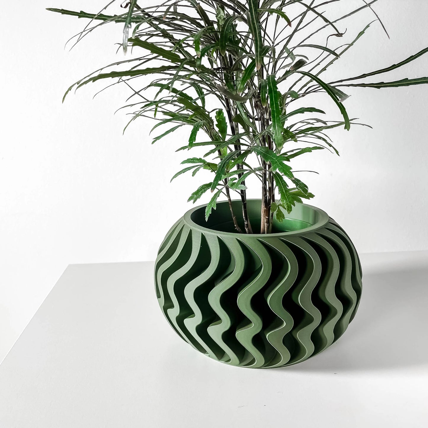 Pot décoratif rond anthracite et vert avec motif ondulé, design contemporain durable en matériaux résistants.