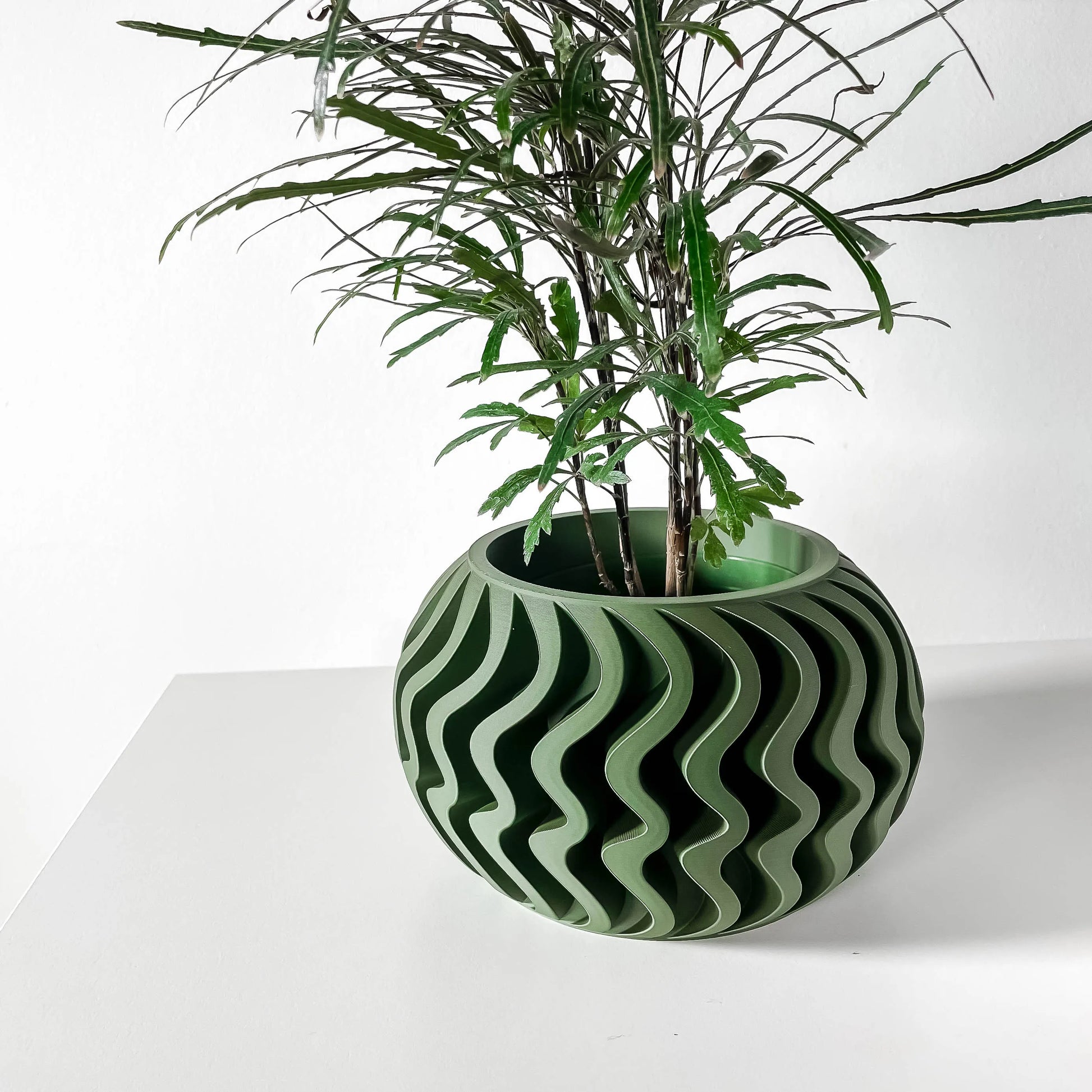 Pot décoratif rond anthracite et vert avec motif ondulé, design contemporain durable en matériaux résistants.