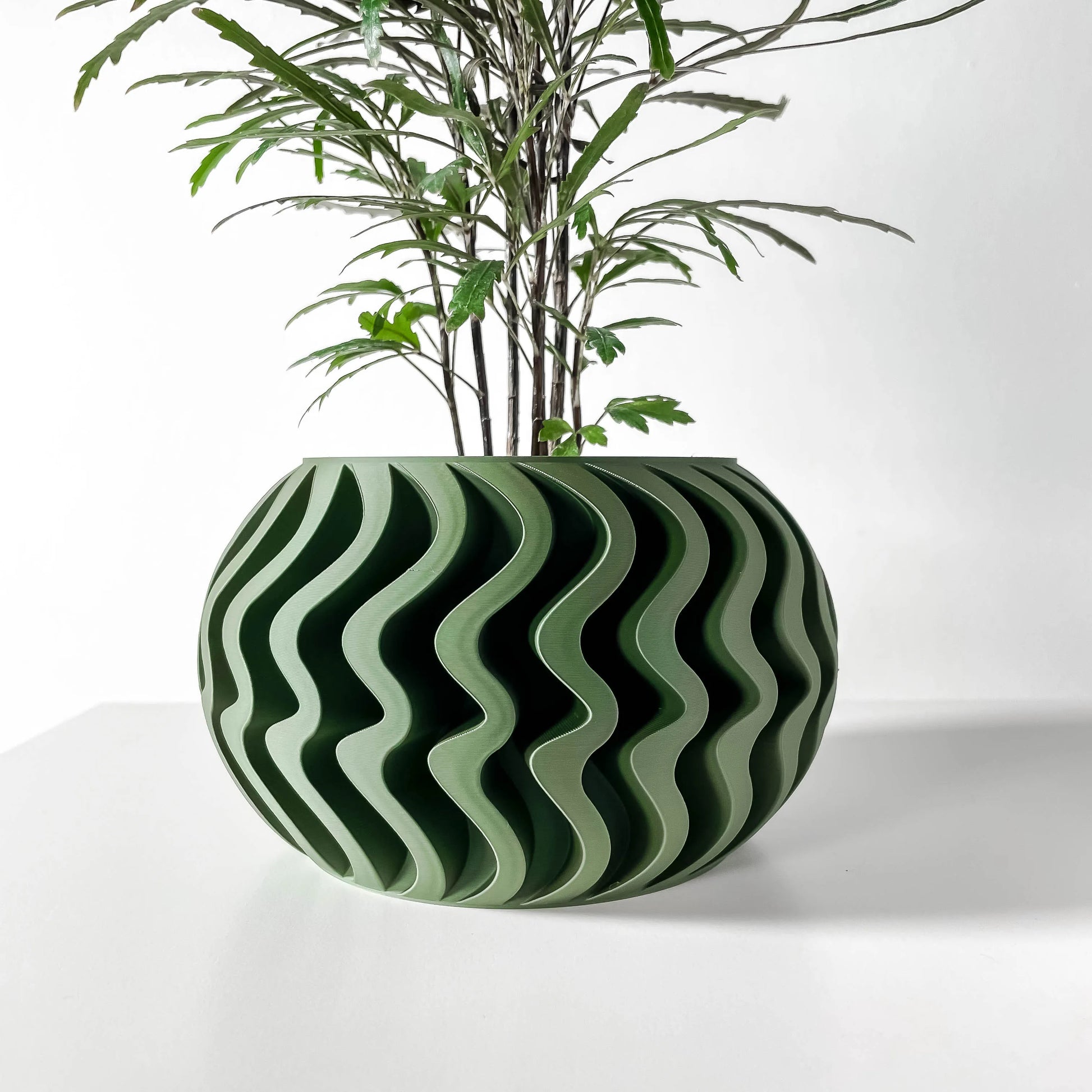 Pot décoratif Noli vert forêt à motif ondulé contemporain, design durable en plastique moderne.