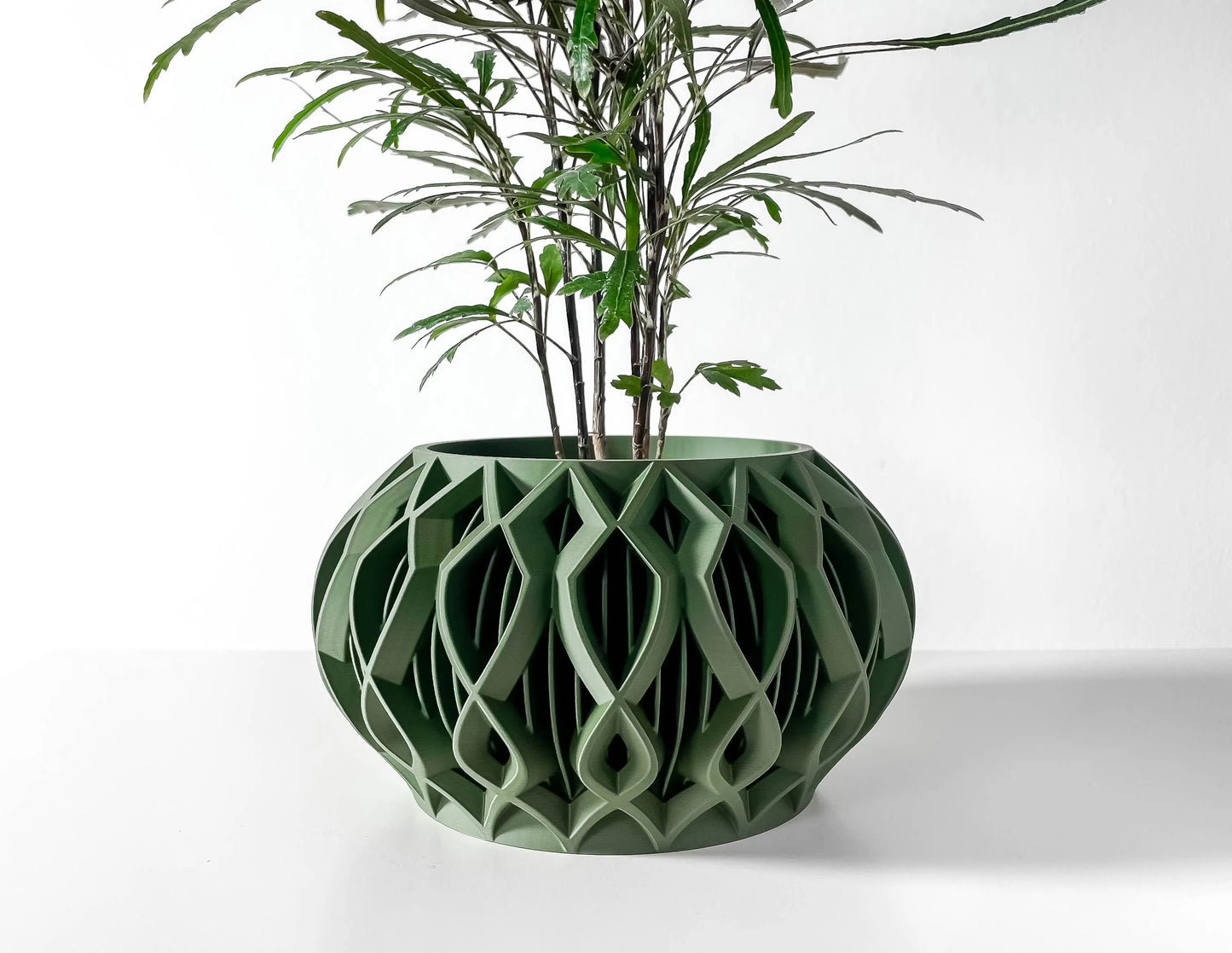 Pot décoratif en plastique vert forêt durable avec design contemporain et motifs géométriques creux.