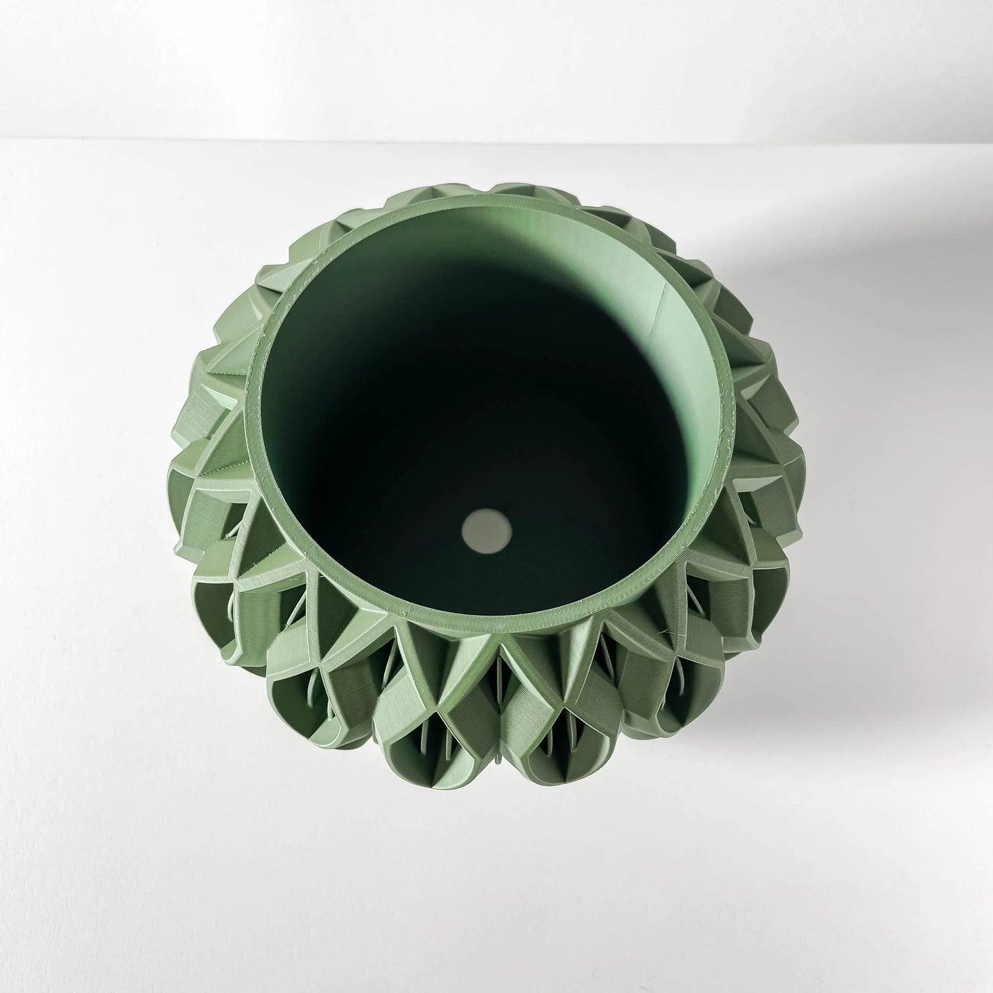 Pot décoratif vert forêt en matériau durable avec design sculpté contemporain et forme octogonale.