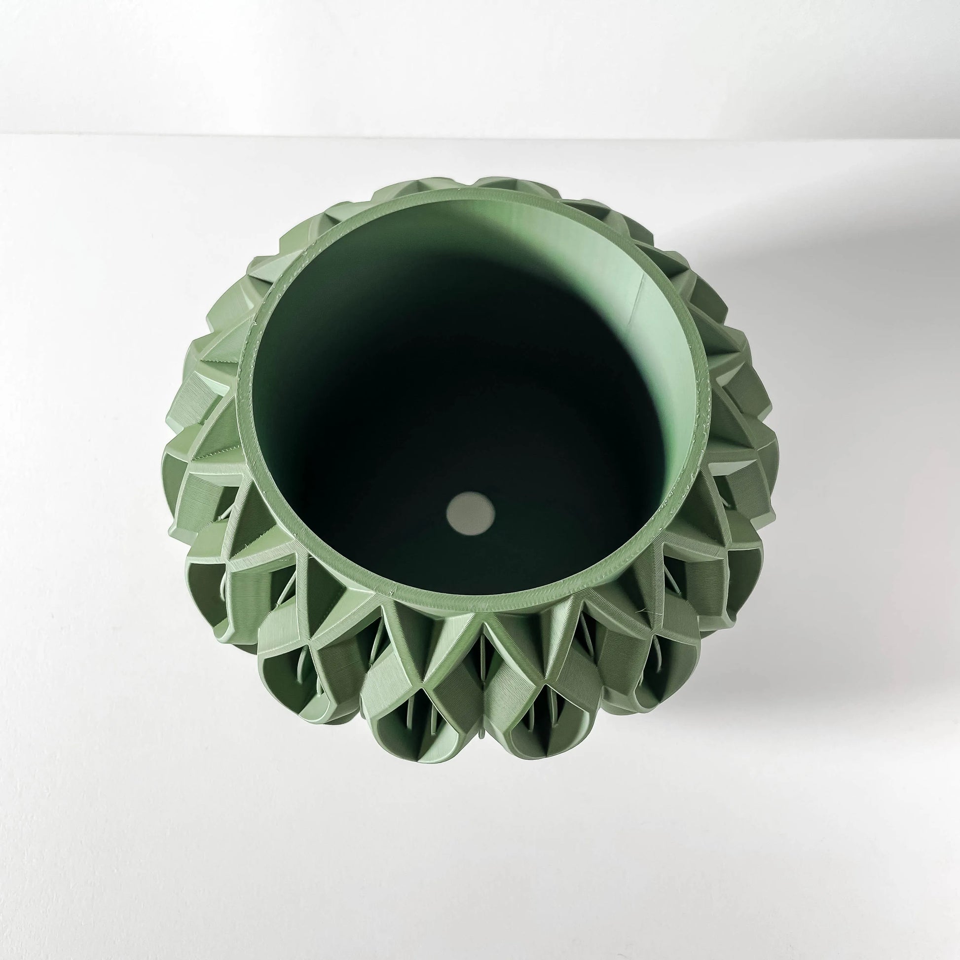 Pot décoratif vert forêt en matériau durable avec design sculpté contemporain et forme octogonale.