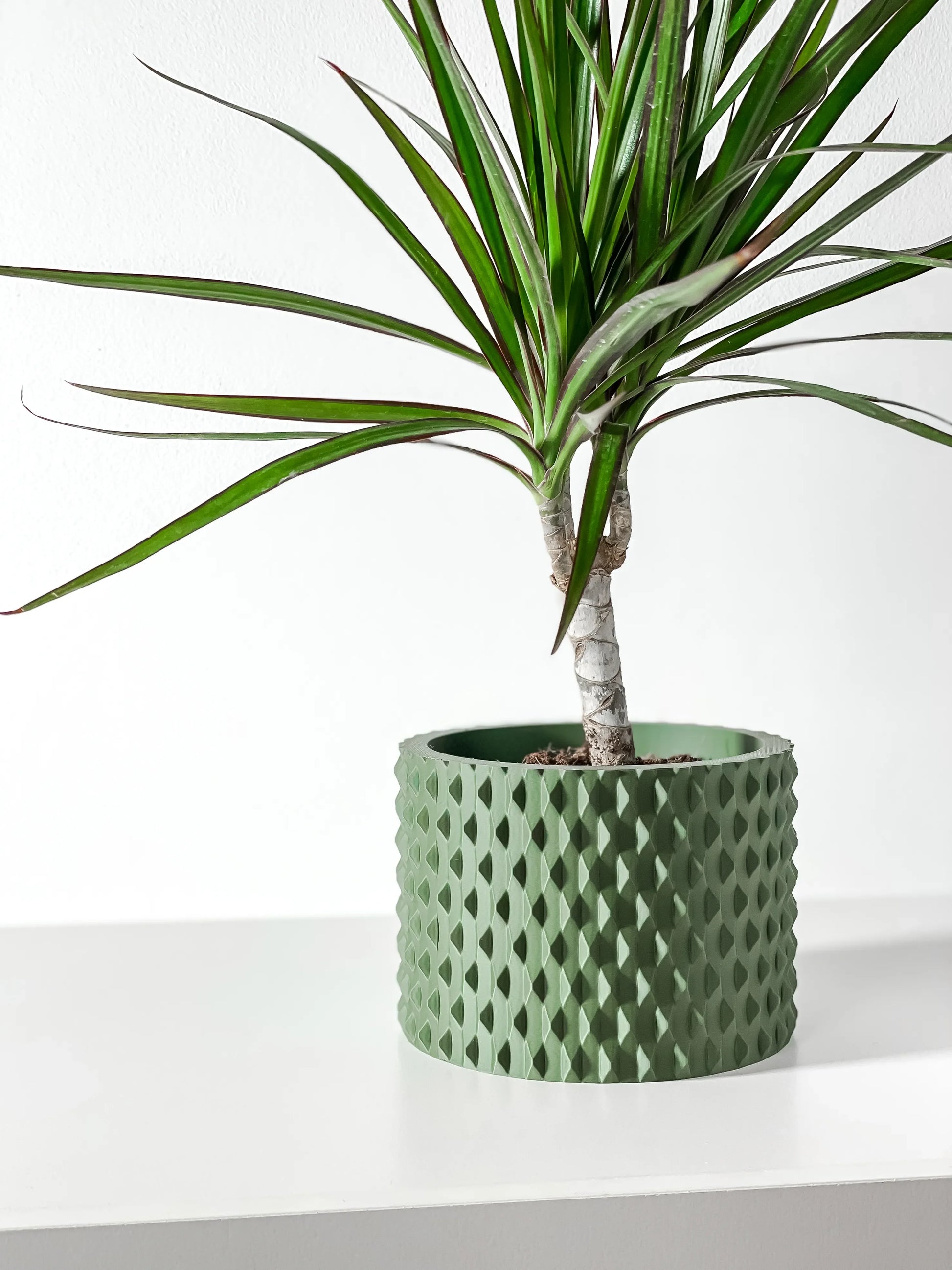 Pot décoratif vert forêt en matériau durable à motif géométrique contemporain, finition mate texturée.