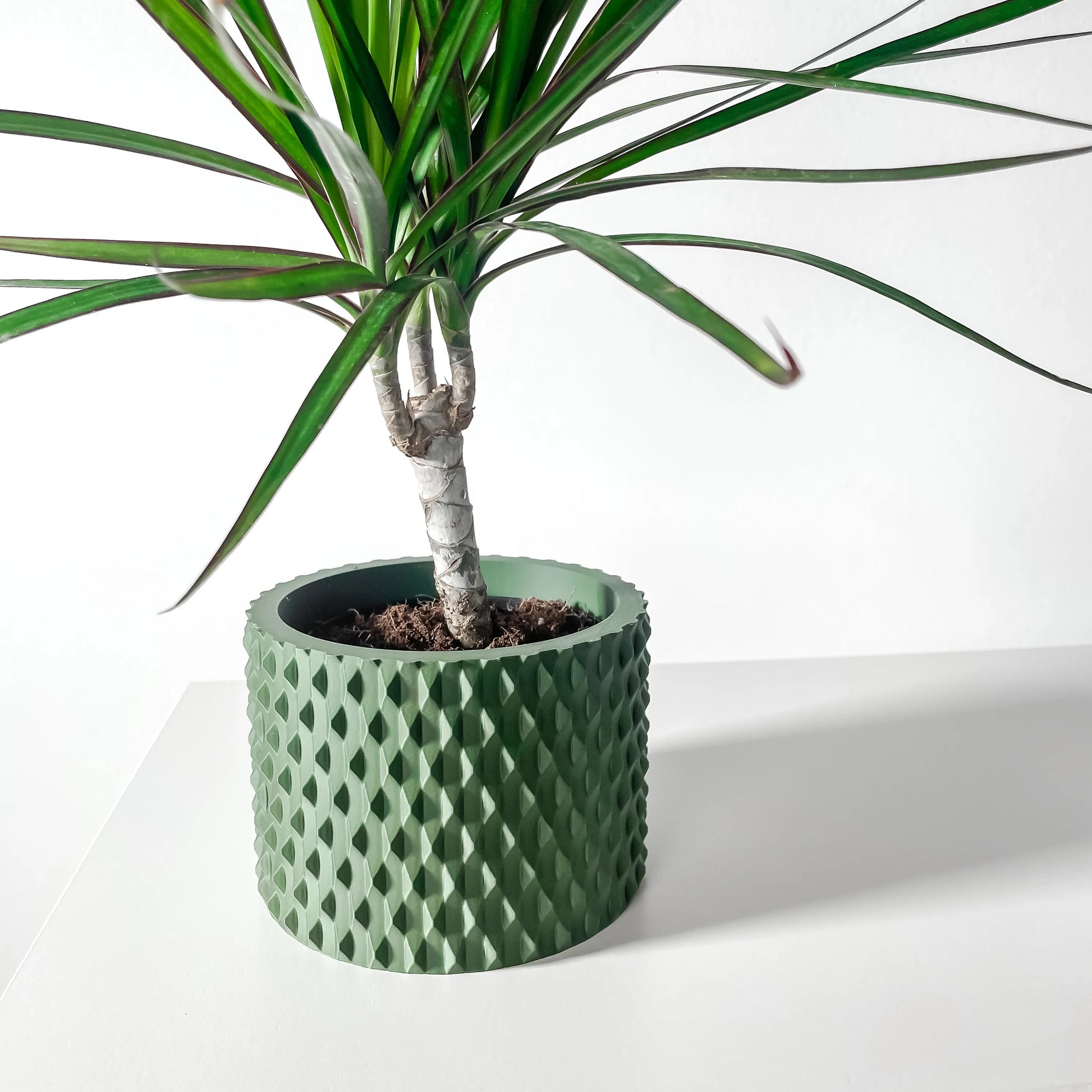 Pot décoratif vert forêt durable au design contemporain avec texture géométrique en relief.