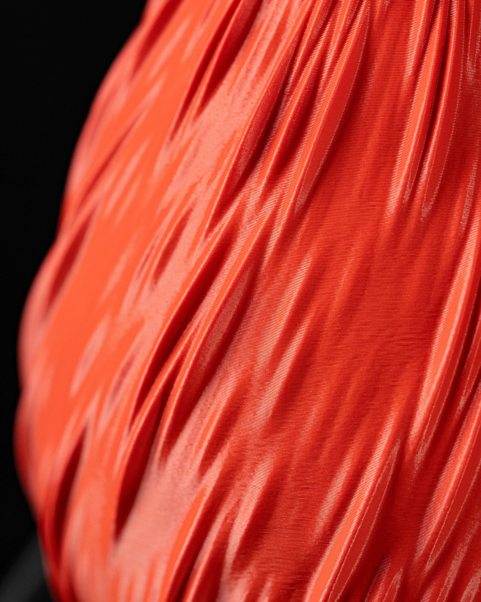 Vase moderne orange vif avec surface texturée en relief imitant des gouttes de pluie, finition lisse et brillante.