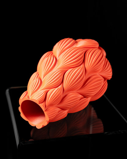 Vase contemporain orange en matériau durable avec design ondulé et reliefs texturés en forme de feuilles.